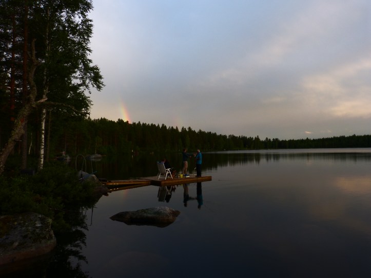 Spöfiske i den spegelblanka Ljussjön. Regnbågen tittar på.